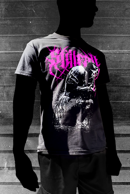 Model wearing a black t-shirt with a kneeling knight, and a magenta "Stillfall" logo behind it